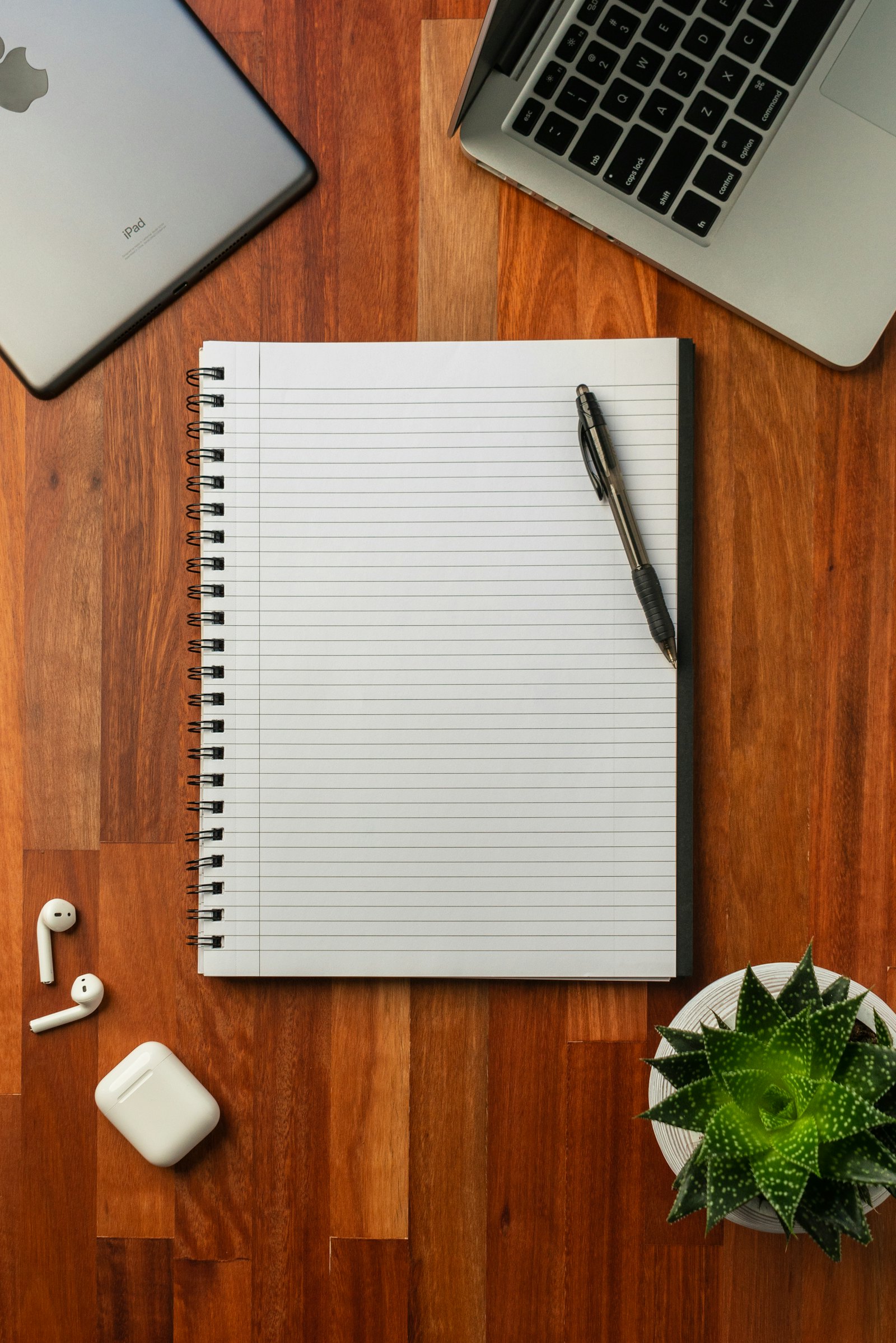 A black pen resting on an open white notebook