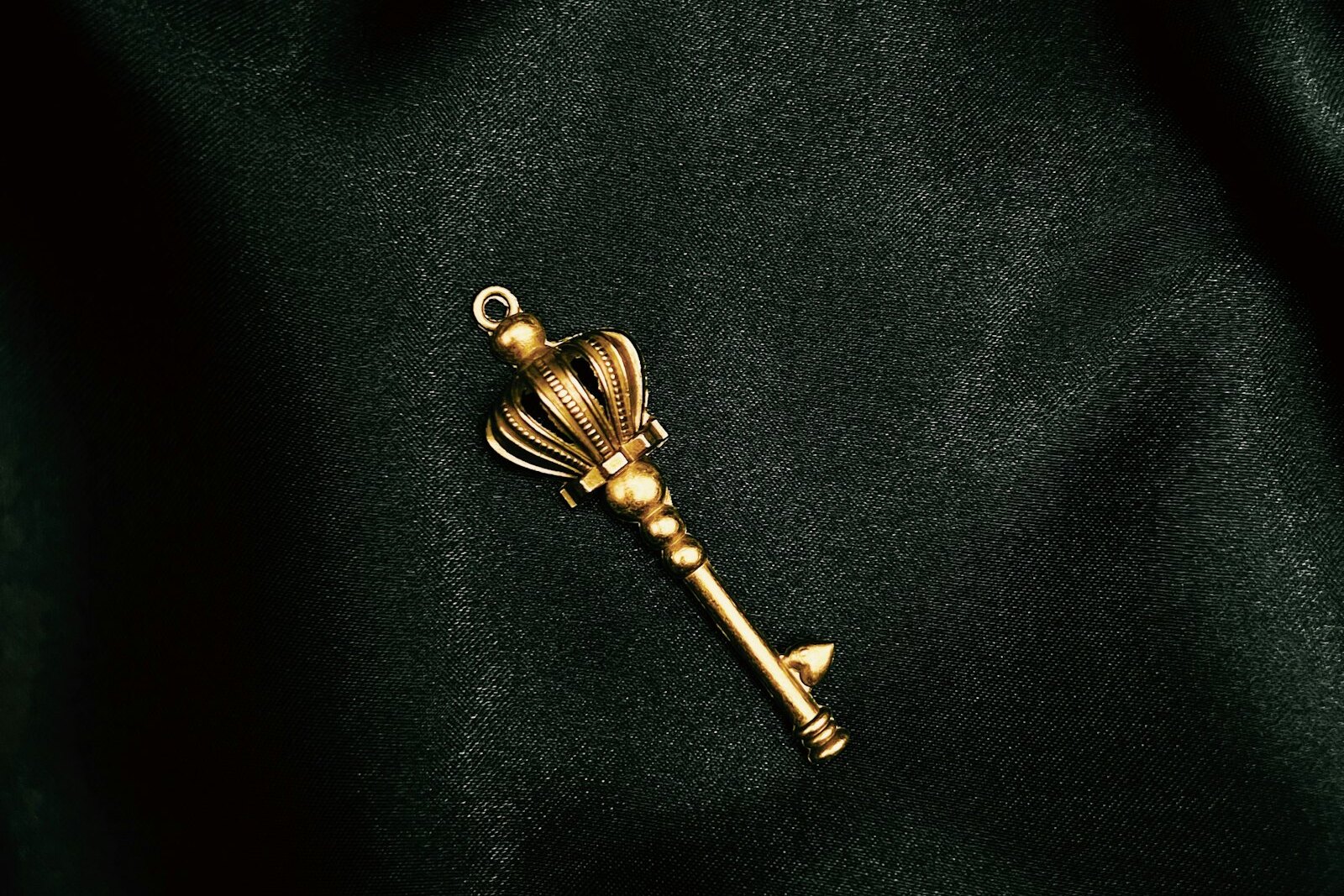 An ornate golden key resting on dark folded velvet